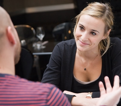 Snímek ženy sedící za stolem s mužem