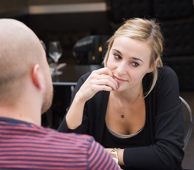 Zamyšlená žena sedící u stolu s mužem