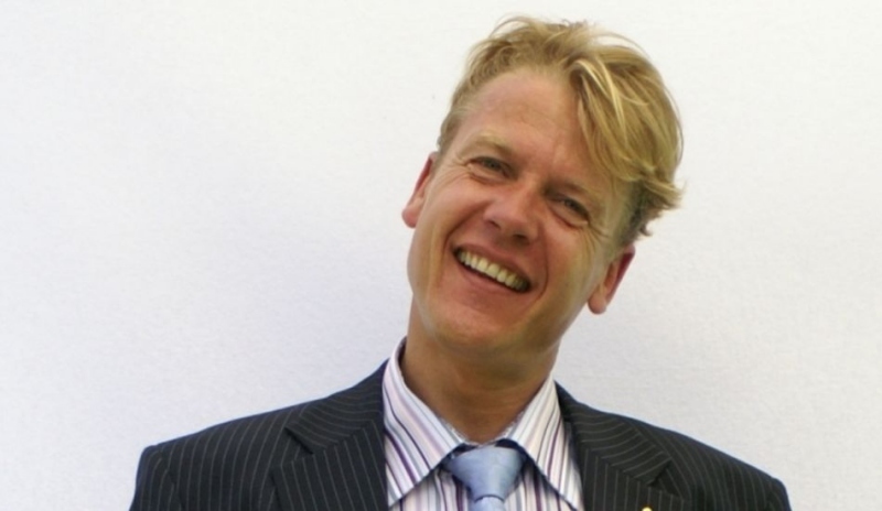 Snímek zobrazující usmívajícího se muže