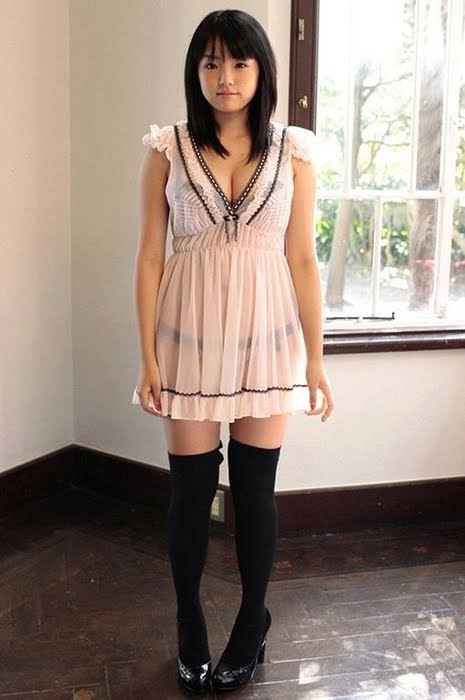 Žena v šatech a černých nadkolenkách uprostřed místnosti