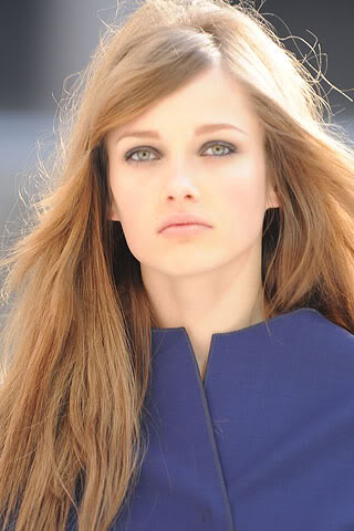 Žena s dlouhými vlasy v modrém kabátku