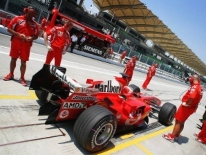F1 v roce 2010 - přehled závodů, změny na startovním poli Pohled na zadní křídlo formule 1 automobilu značky Ferrari stojící s mechaniky v depu