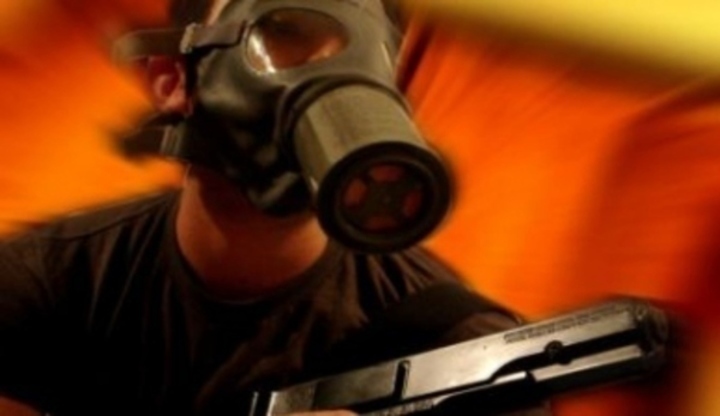 Zbraně - pistole jako miláček Voják zachycen na fotografii s plynovou maskou a se zbraní