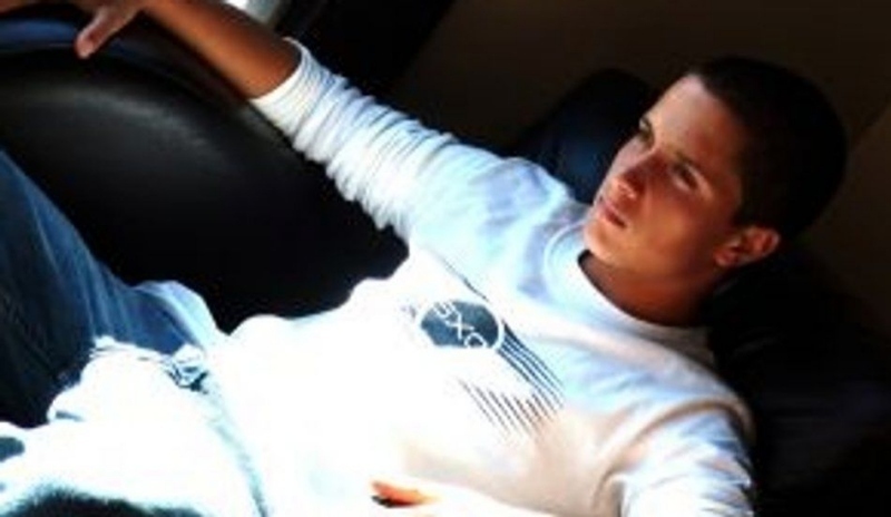 Fotografie muže v bílém tričku ležící na pohovce