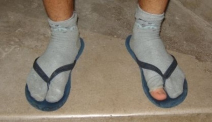 Fotografie pánské obuvi-žabek s ponožkami a dírou na palci