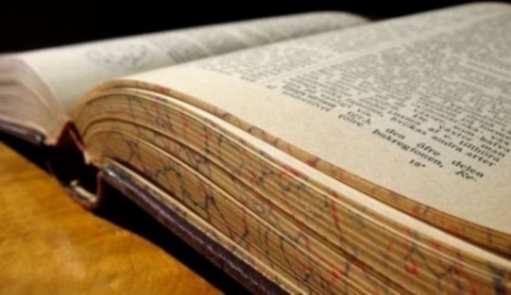 Jak se naučit cizí jazyk? Fotografie otevřené knihy ležící na stole