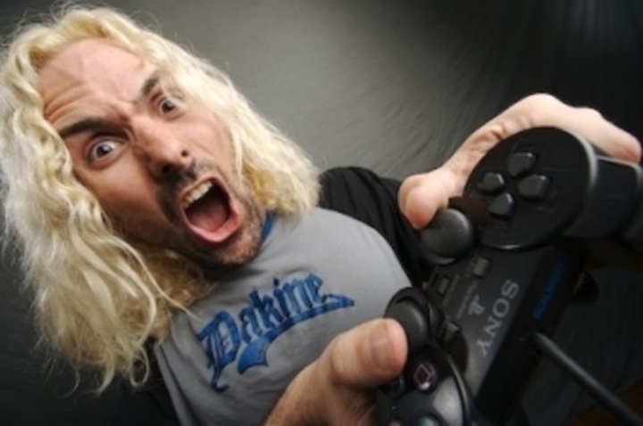 Jak se odnaučit závislosti na počítačových hrách Fotografie muže s detailem na herní konzolu, kterou drží v rukou