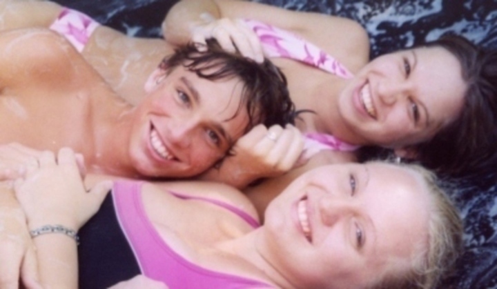 Fotografie zachycující trojici mladých lidí, ležících vposteli