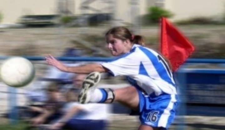 Snímek zachycující výkop fotbalisty při fotbalovém zápase