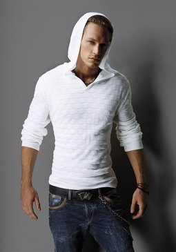 Muž stojící v bílém svetru s kapucí na hlavě