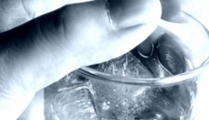 Černobílá fotografie ruky, která drží sklenici