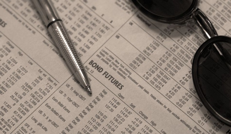 Foto dluhopisů s propiskou a slunečními brýlemi