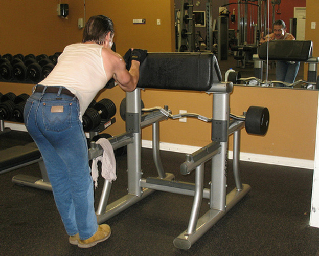 Fotografie ženy cvičící na posilovacím stroji