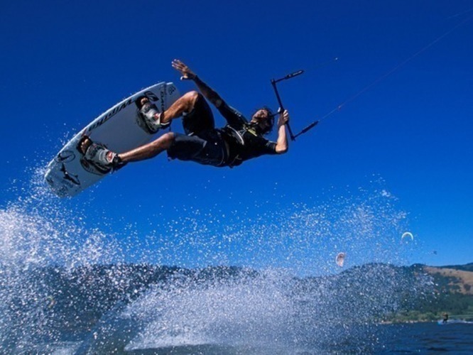 Fotografie muže provádějící Kiteboarding v moři