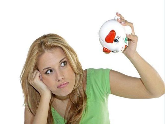 Fotografie ženy, držící v ruce pokladničku