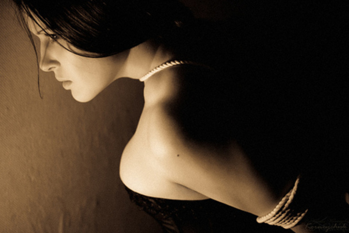 Černobílá fotografie ženy, která polonahá pózuje