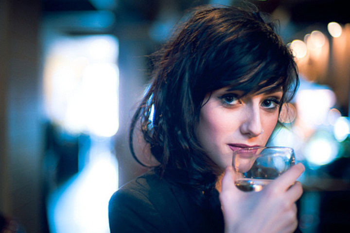 Fotografie ženy, držící v ruce sklenku vína