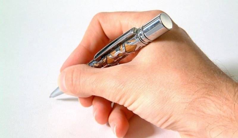 Fotografie ruky držící propisku