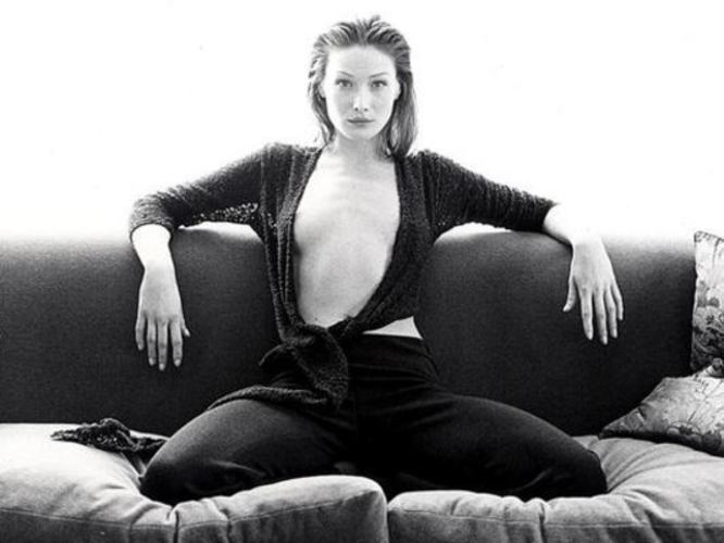 Sexy první dáma – Carla Bruni Černobílá fotografie ženy sedící na pohovce