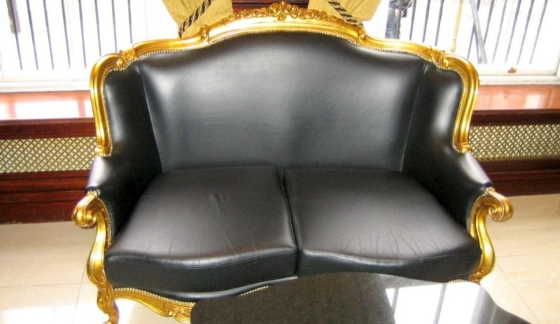 Snímek černého dvojkřesla se zlatým rámem