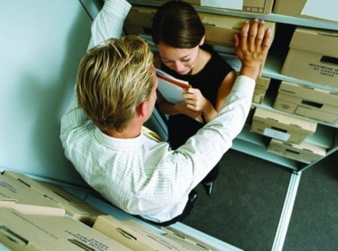 Fotografie muže a ženy v kanceláři mezi kartotékou