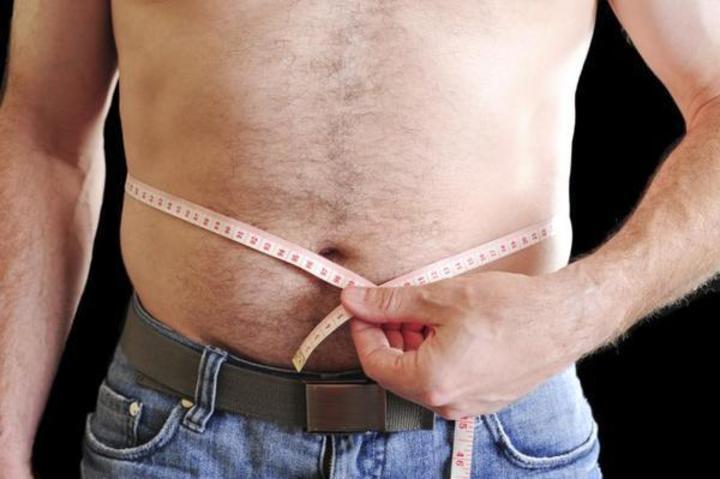 Velikosti v pánské módě – jak se v nich vyznat? Fotografie muže měřící si obvod pasu