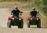 Dvě osoby jedoucí na čtyřkolkách Dvě osoby jedoucí na čtyřkolkách