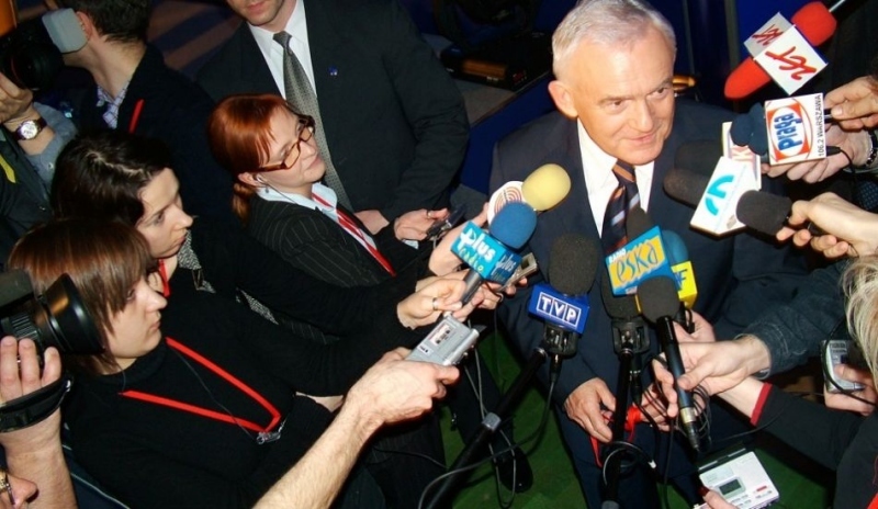 Fotografie muže obklopeného reportéry s mikrofony