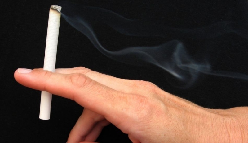 Fotografie ruky držící cigaretu