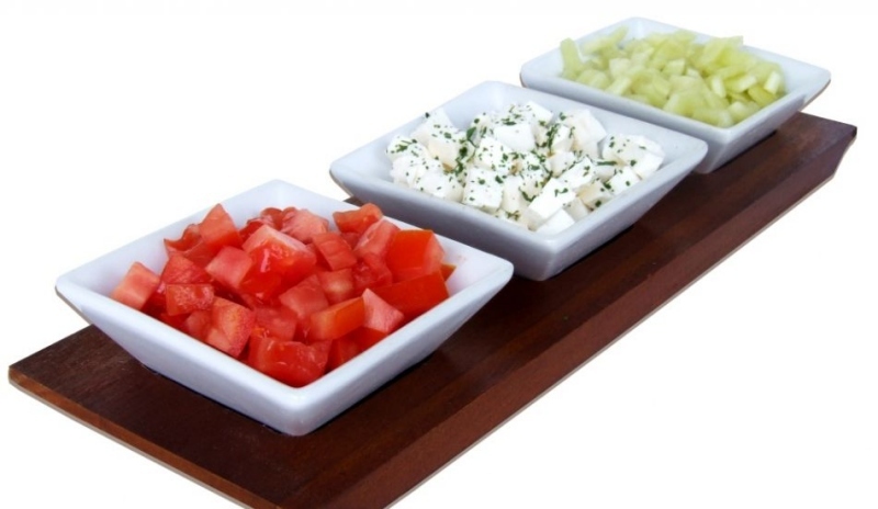 Fotografie tří misek s jídlem na hnědé desce