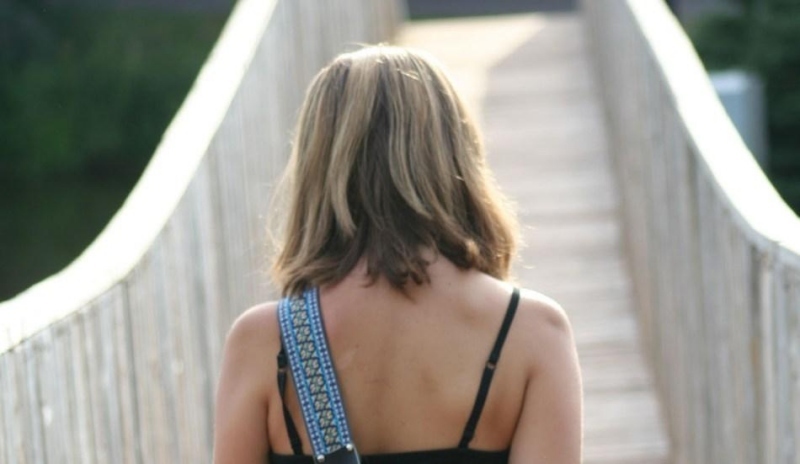 Fotografie ženy kráčející po můstku