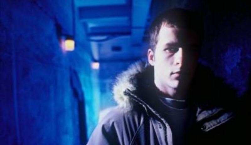 Fotografie muže v bundě na modrém pozadí