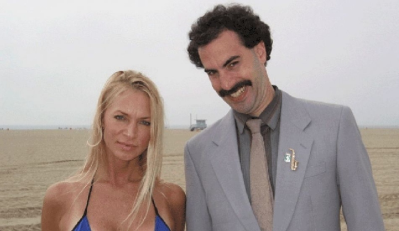 Muž v obleku s knírem se ženou v modrých plavkách