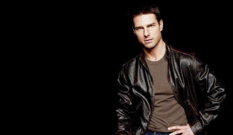 Tom Cruise v černé kožené bundě na černém podkladu