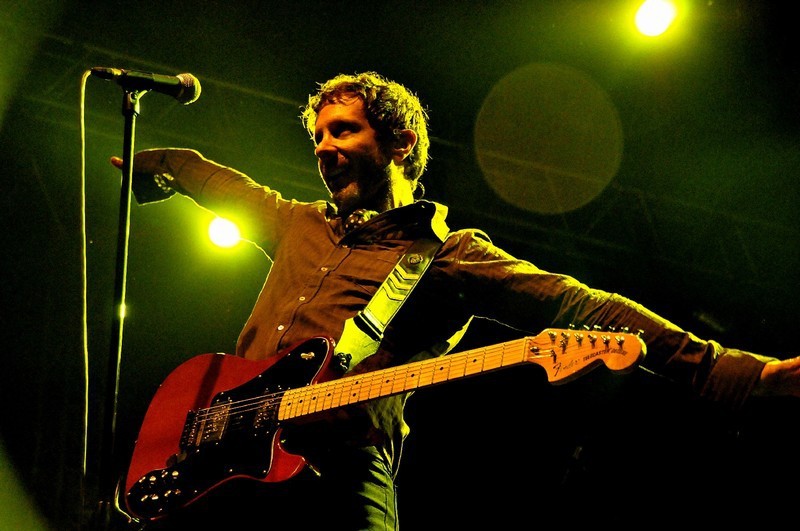 Muž s kytarou na pódiu