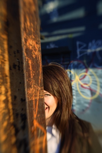 Anna K s úsměvem na tváři schovaná za sloupem