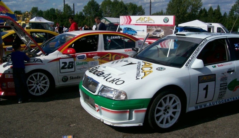 Obrázek závodních aut stojících na parkovišti