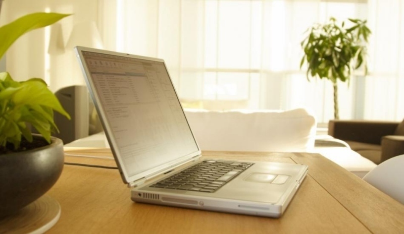Fotografie bílého notebooku, který leží na jídelním stole