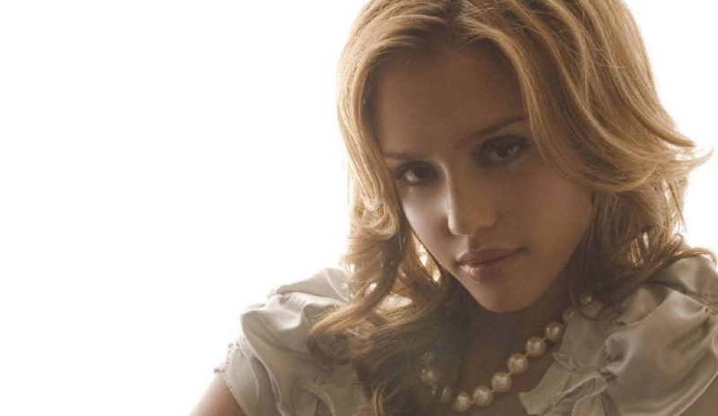 Fotografie blondýnky v bílé halence s perlami na krku