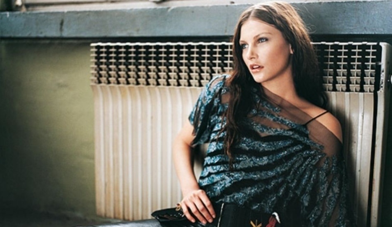 Fotografie ženy v modročerné halence sedící u radiátoru