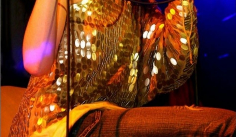 Iva Frühlingová ve zlaté halence a hnědých kalhotách na koncertu