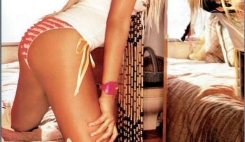 Fotografie ženy v plavkách stojící před zrcadlem