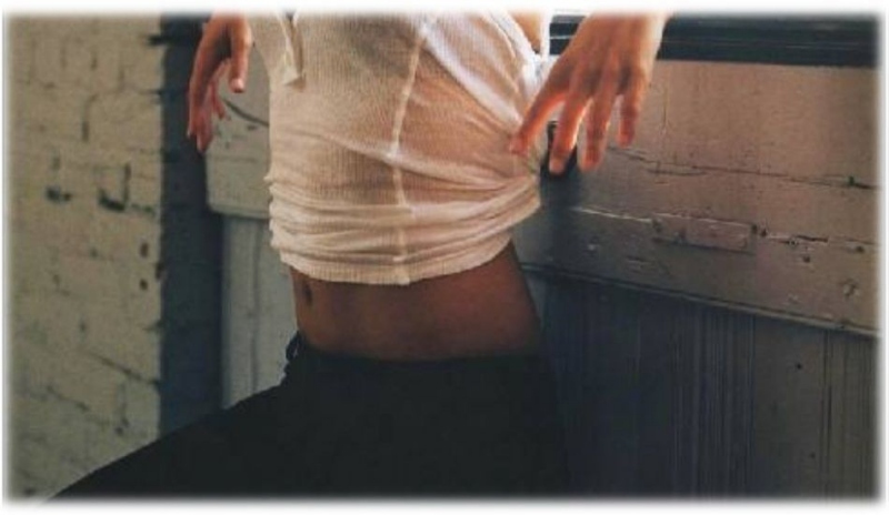 Fotografie ženy v kalhotech s odhaleným břichem