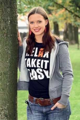 Kristýna Leichtová s hezkým úsměvem opírající se o strom