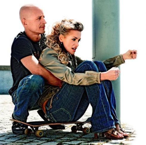 Dara Rolins sedí na skateboardu 