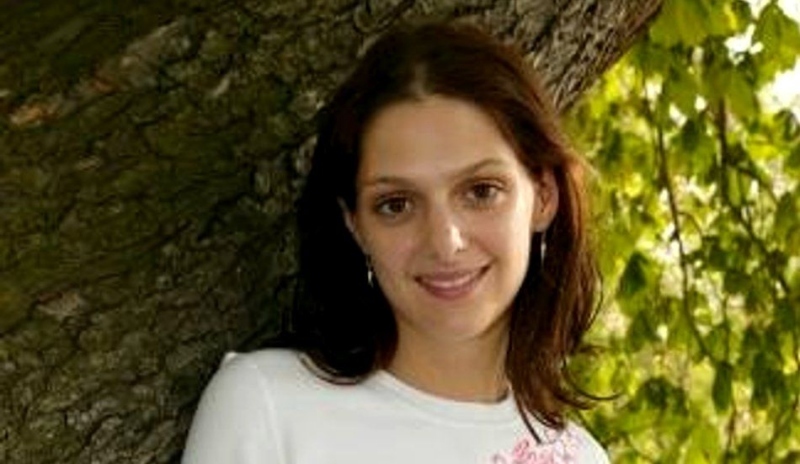 Klára Issová s úsměvem na tváři opírající se o strom