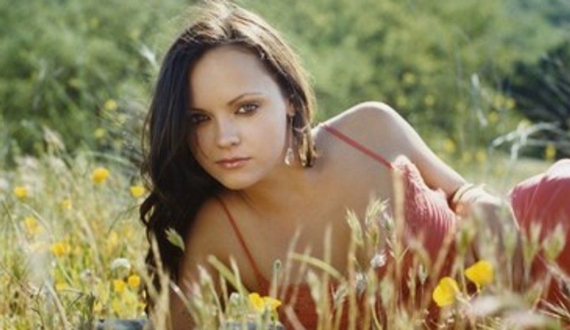 Christina Ricci ležící na louce mezi květy