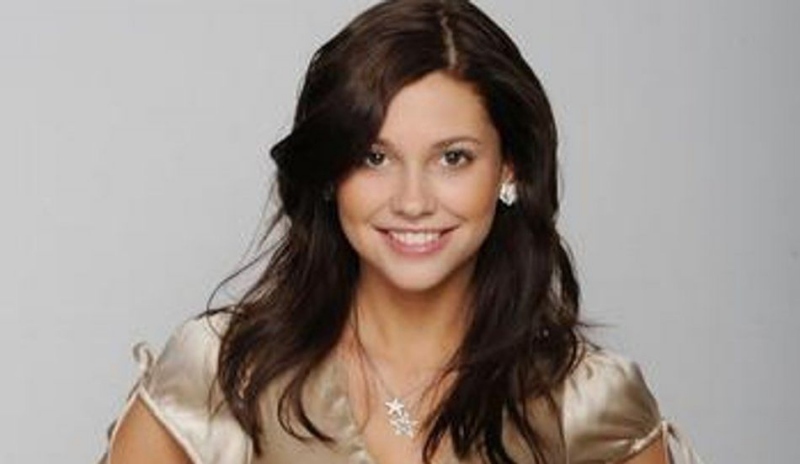 Fotografie usmívající se brunety v sametové halence