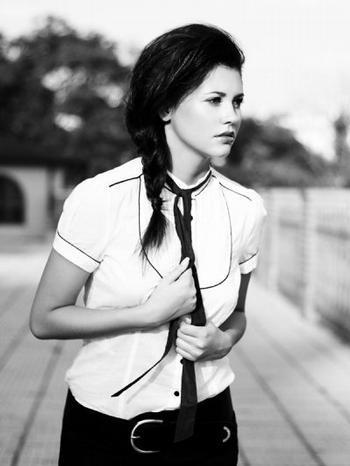 Hana Svobodová v bílé halence se zapleteným copem jde po ulici