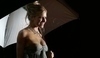 Sienna Miller pózující v šedých šatech s deštníkem v ruce